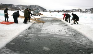 Volunteers clear ice from the lanes where swimmers will compete in the first US Winter Swimming Championships at Lake Memphremagog in Newport, Vermont, USA 21 February 2015.